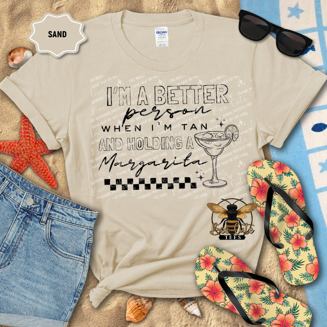 Beige t-shirt with beach-themed design and text, surrounded by flip-flops, sunglasses, and beach accessories.