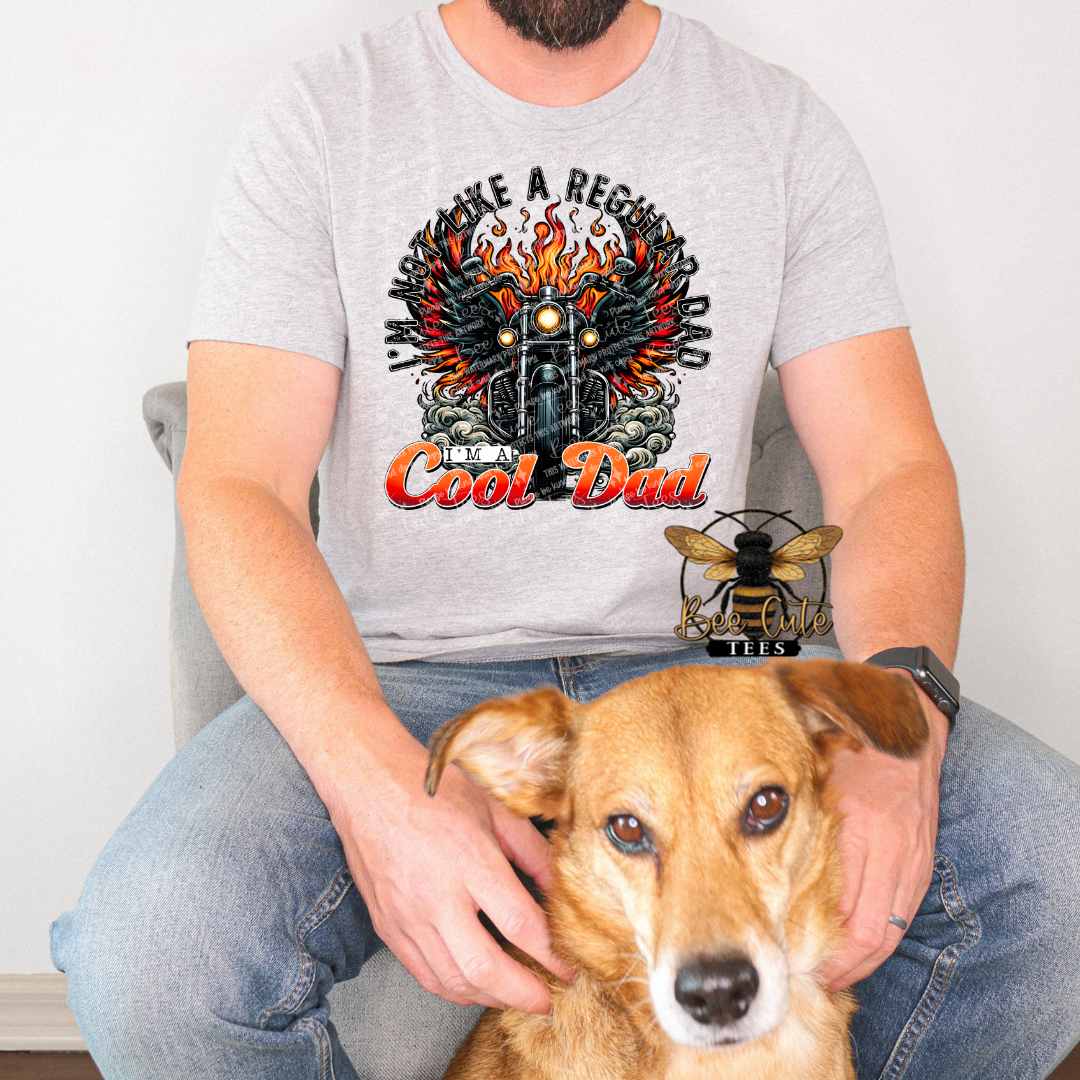 Person wearing a t-shirt with a graphic design and holding a dog.