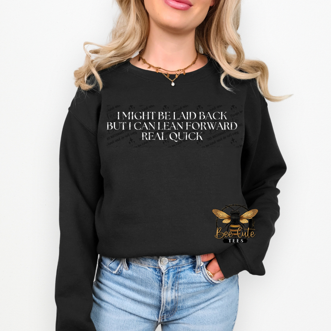 Person wearing a black sweatshirt with text and blue jeans on a white background