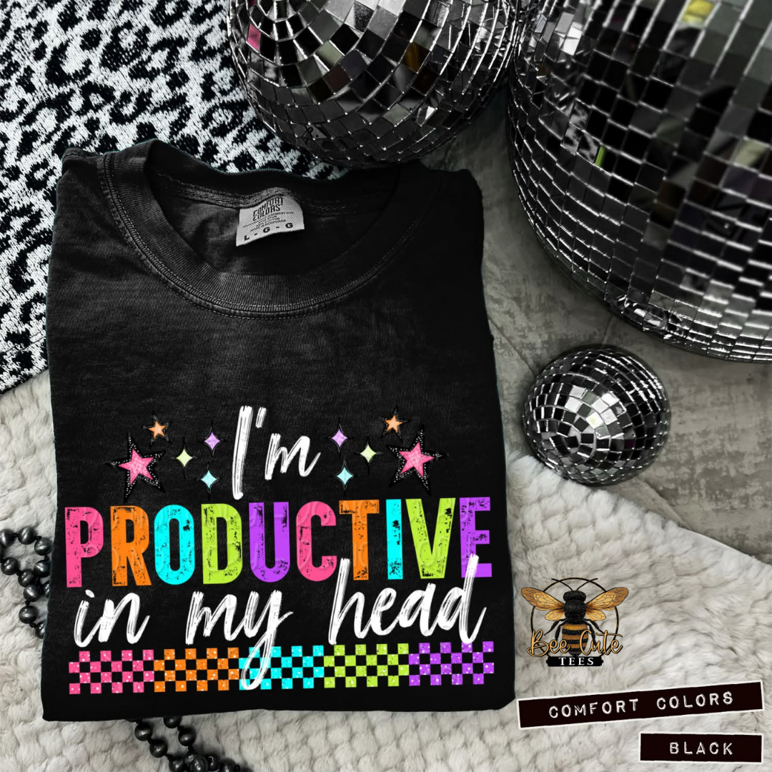 Black t-shirt with colorful text 'I'm productive in my head' on a textured surface with disco balls.