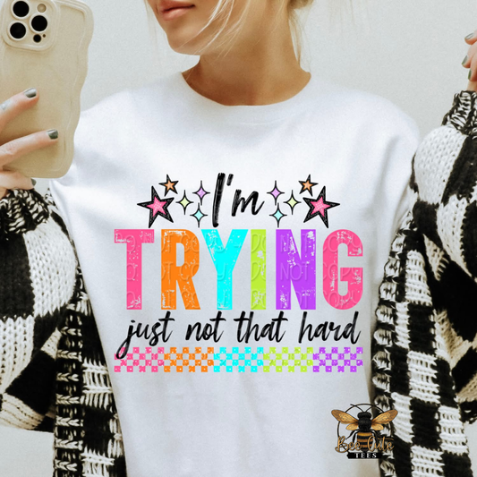 Person wearing a white sweatshirt with colorful text design and a brand logo.