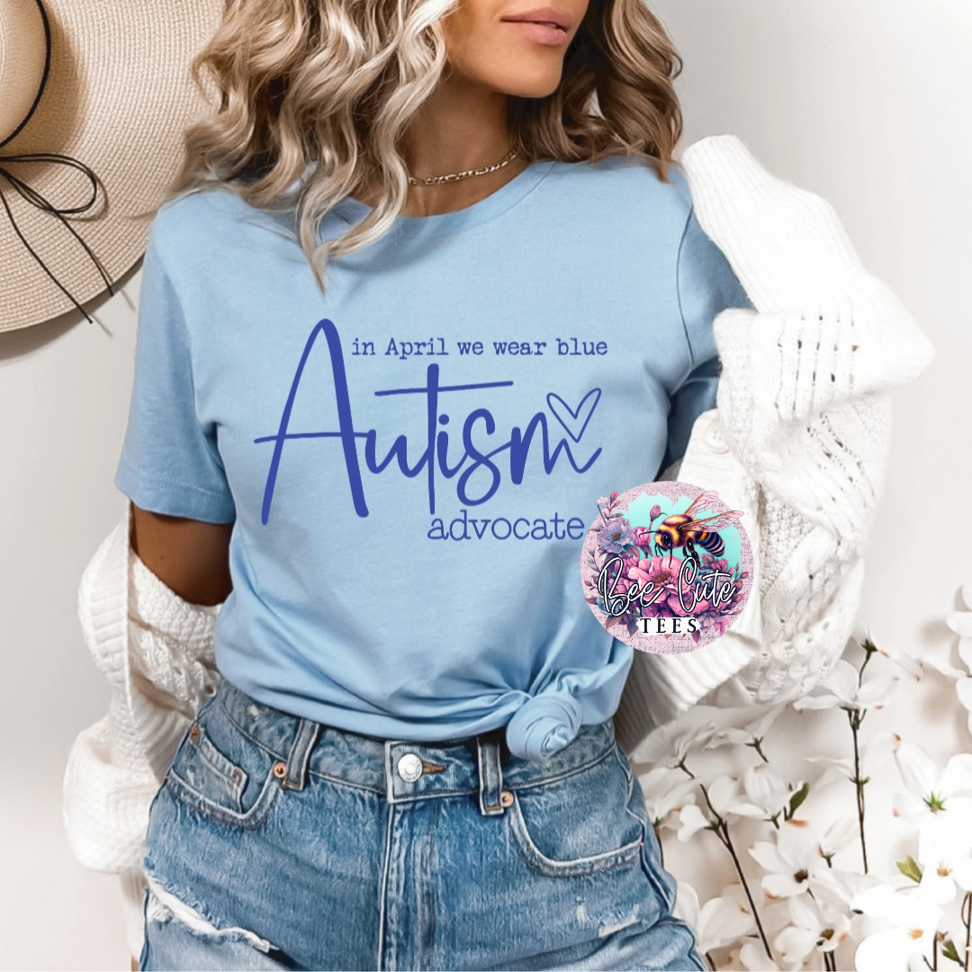 A person wearing a blue t-shirt with the text 'In April we wear blue - Autism advocate' printed on it, paired with denim jeans.