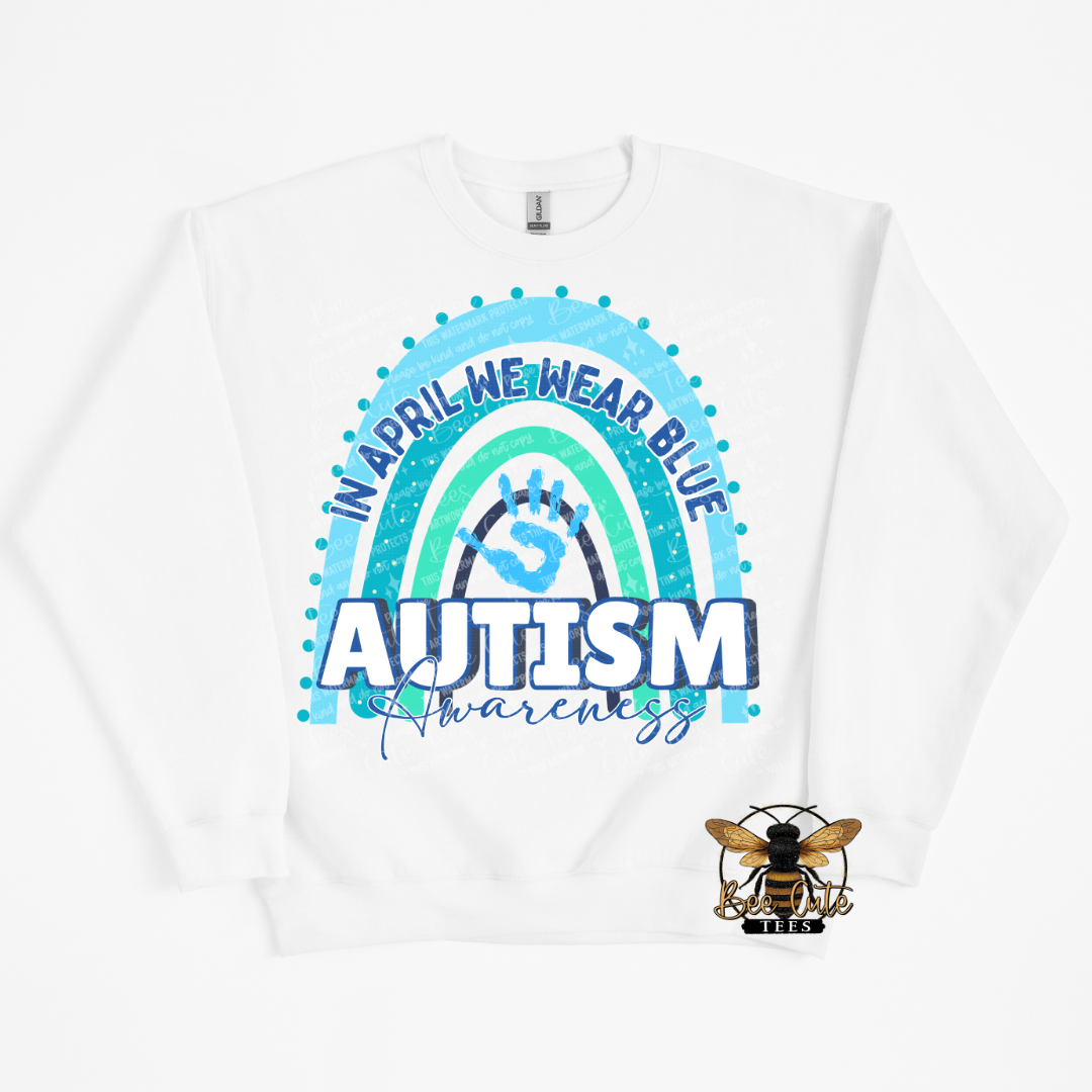 White sweatshirt with autism awareness design featuring a rainbow and text.