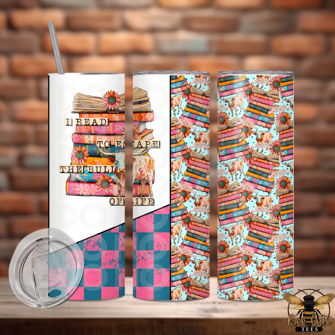 Tumbler with book-themed design and text on a wooden surface with brick wall background