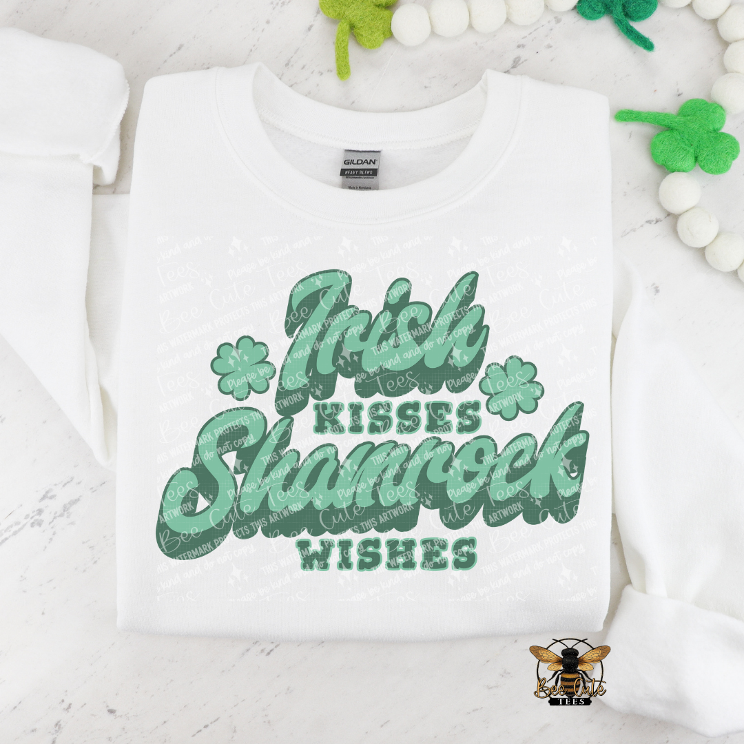White sweatshirt with green text 'Irish Kisses Shamrock Wishes' on a white background with decorative elements.