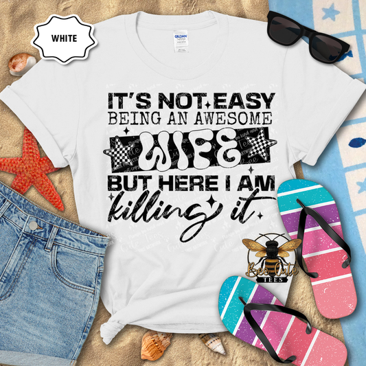 White t-shirt with humorous text design on a beach-themed background with sunglasses, flip-flops, and denim shorts.