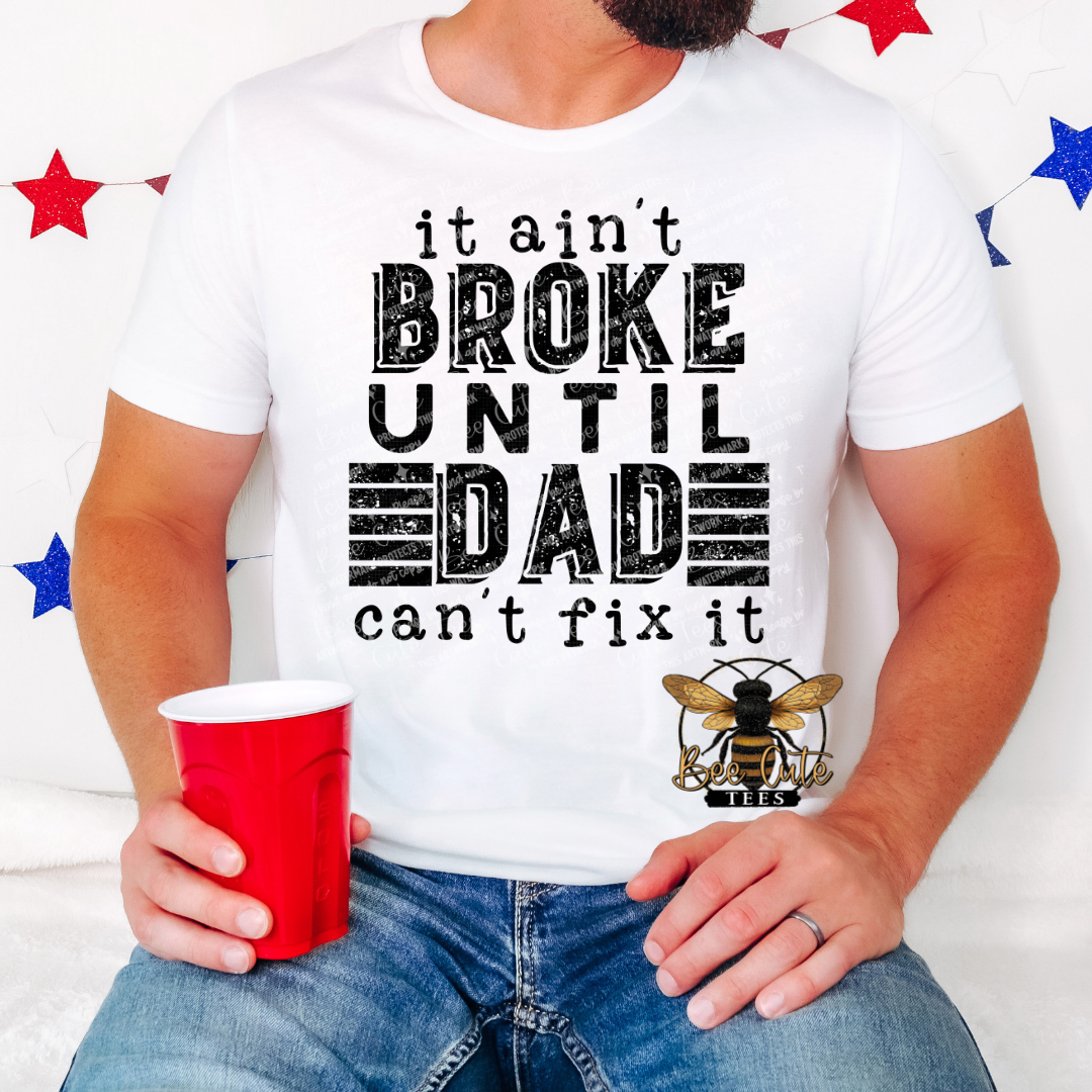 Person wearing a white t-shirt with a humorous graphic and text, holding a red cup.