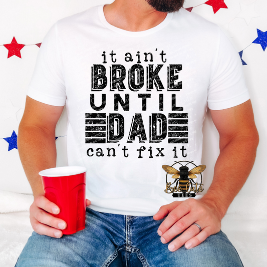 Person wearing a white t-shirt with a humorous graphic and text, holding a red cup.