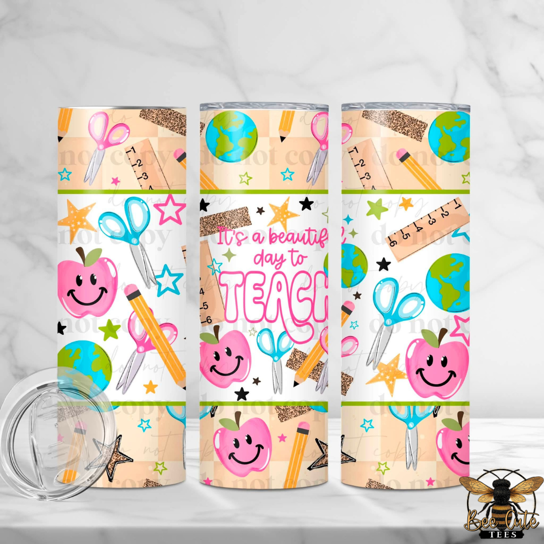 Three views of a 20 oz skinny tumbler with a school-themed print, including pink apples, scissors, pencils, stars, and the text 'It's a beautiful day to TEACH'. A clear lid is shown in the bottom left on a white marble background.