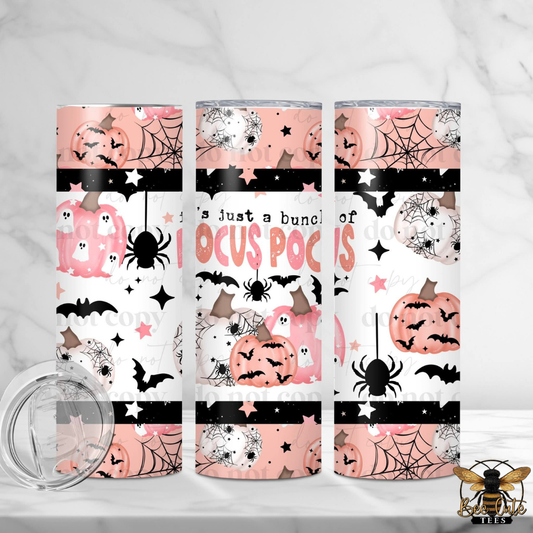 Three tall skinny tumblers with a pink, black, and white 'Hocus Pocus' Halloween pattern, shown on a white marble background with a clear lid in the foreground.