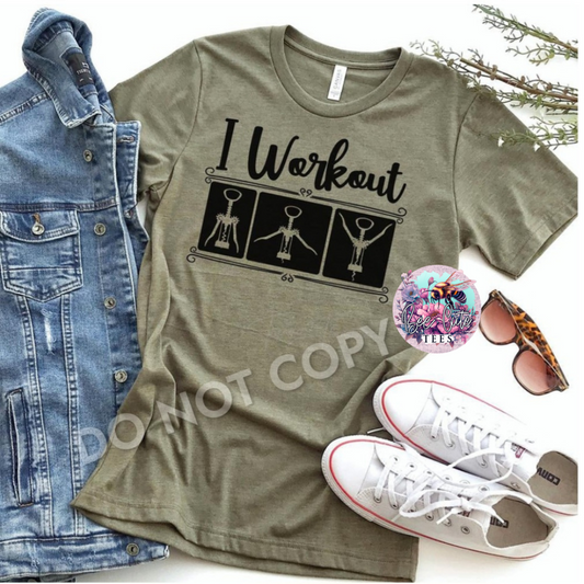 Olive green t-shirt with 'I Workout' graphic, denim jacket, white sneakers, and sunglasses on a white background.
