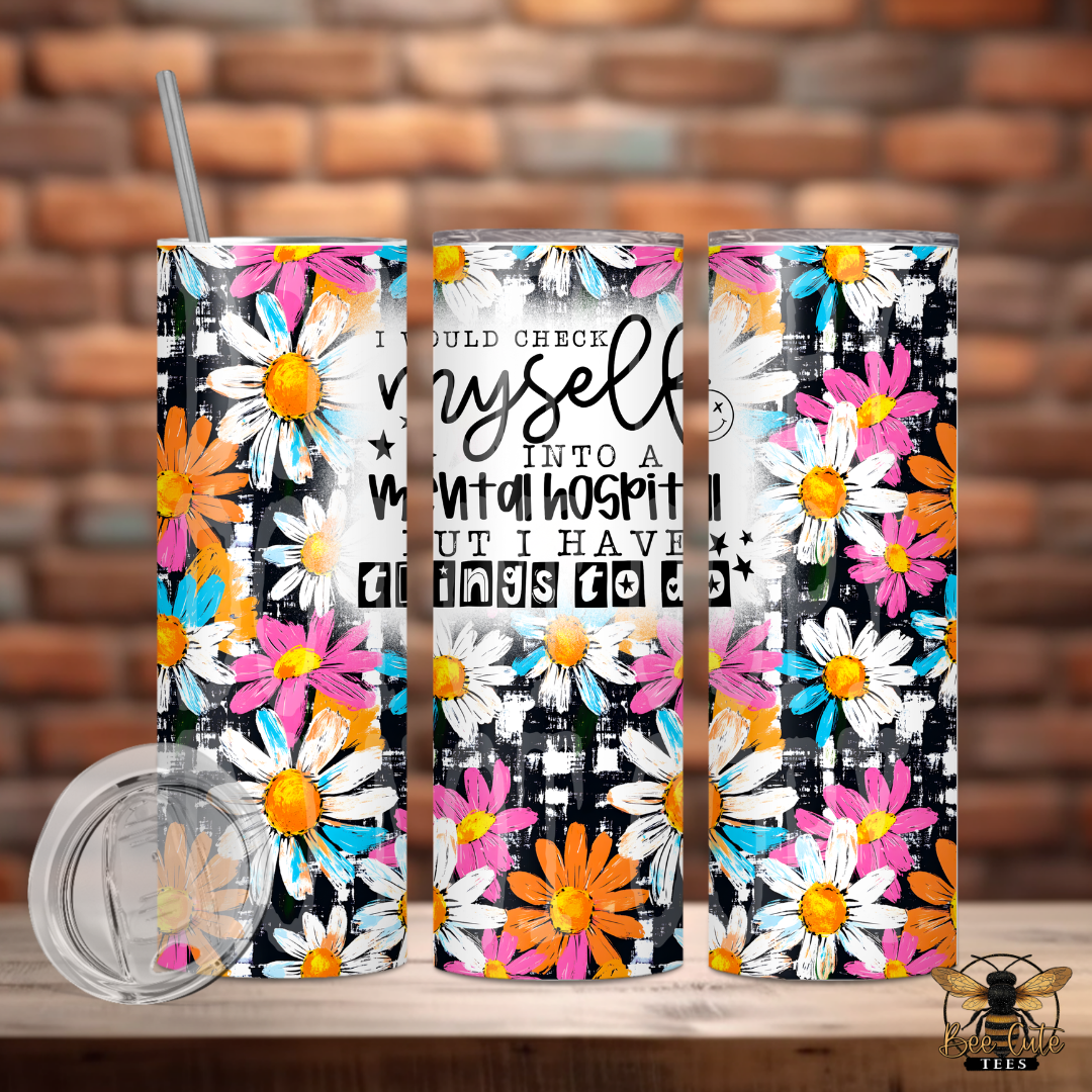 Three floral tumblers with a humorous quote on a wooden surface with a brick wall background.