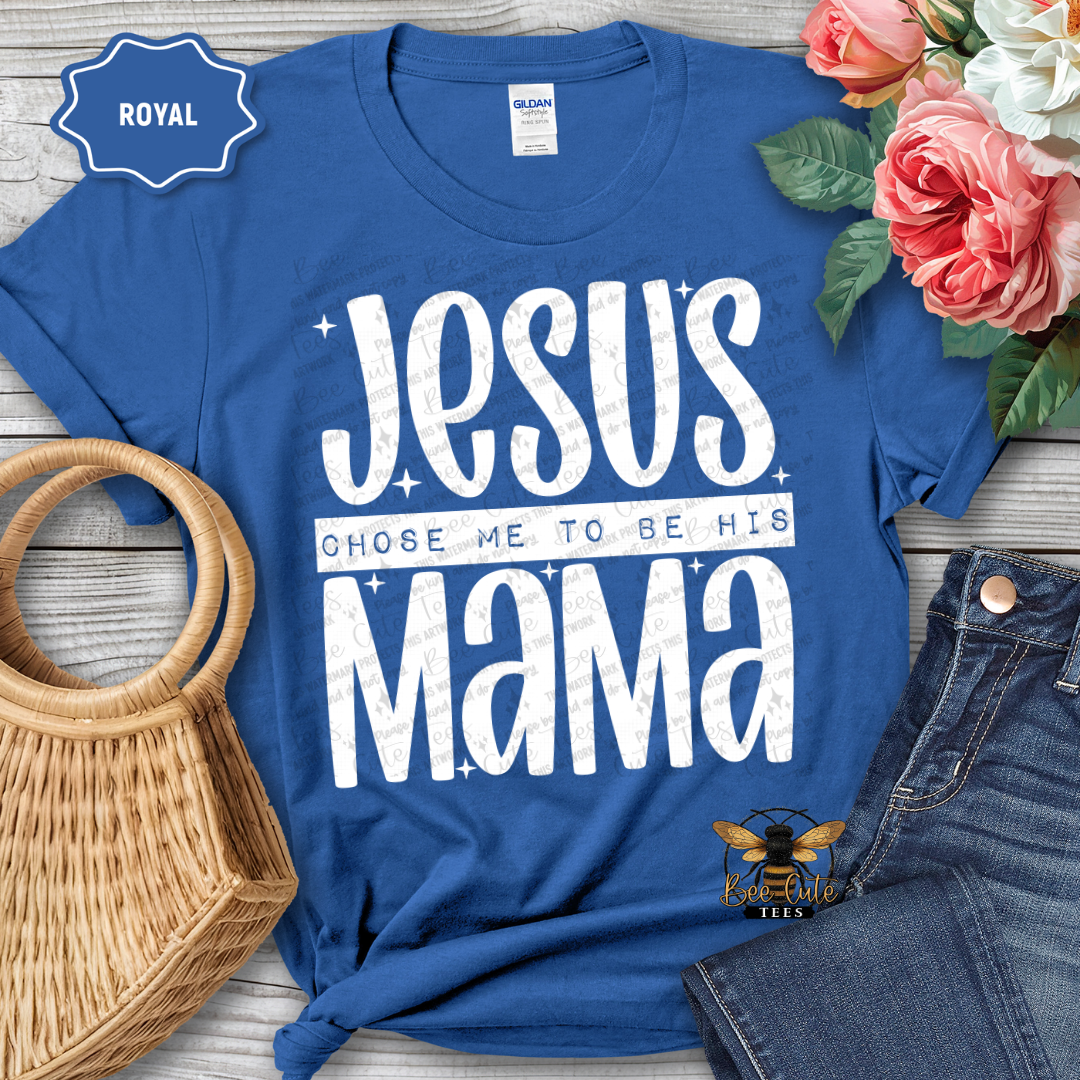 Blue t-shirt with 'Jesus Chose Me to Be His Mama' text, surrounded by flowers and jeans on a wooden surface.