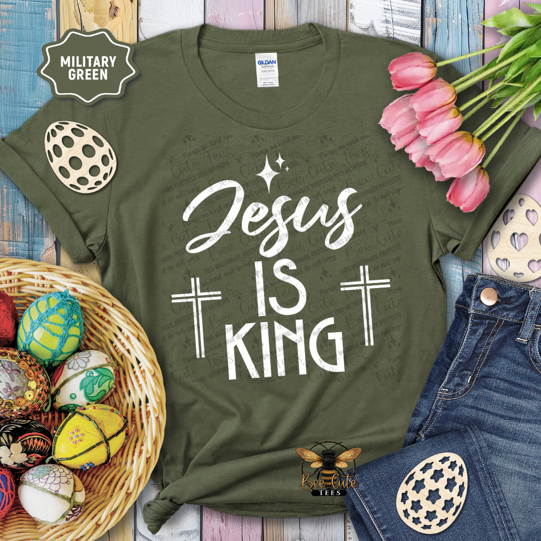 Green t-shirt with 'Jesus is King' text, surrounded by Easter decorations on a wooden surface.