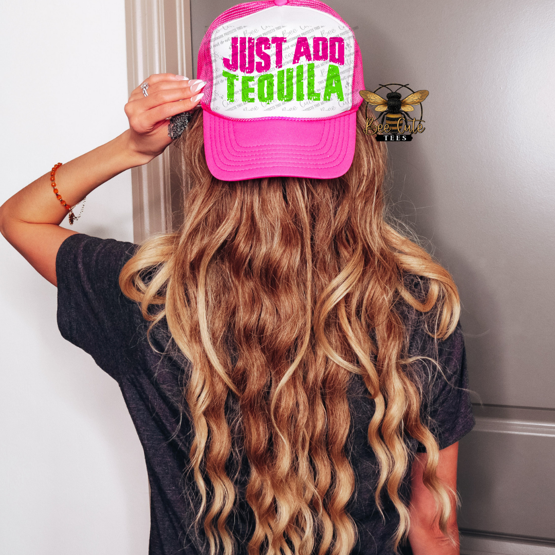 Person wearing a pink cap with 'Just Add Tequila' text, standing against a neutral background