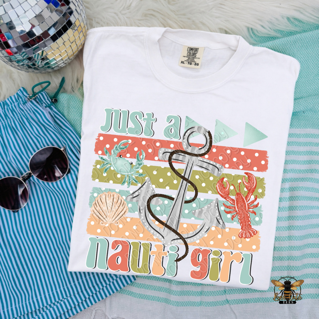 Folded t-shirt with 'Just a nauti girl' design on a striped fabric background