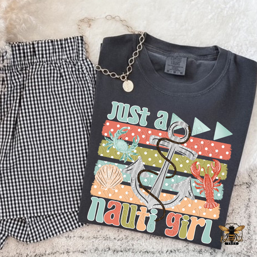 Black t-shirt with 'Just a nauti girl' design and checkered pants on a textured surface