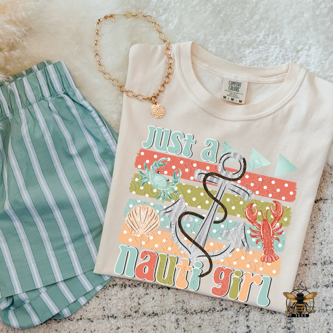 Beige t-shirt with 'Just a nauti girl' design and green shorts on a textured surface