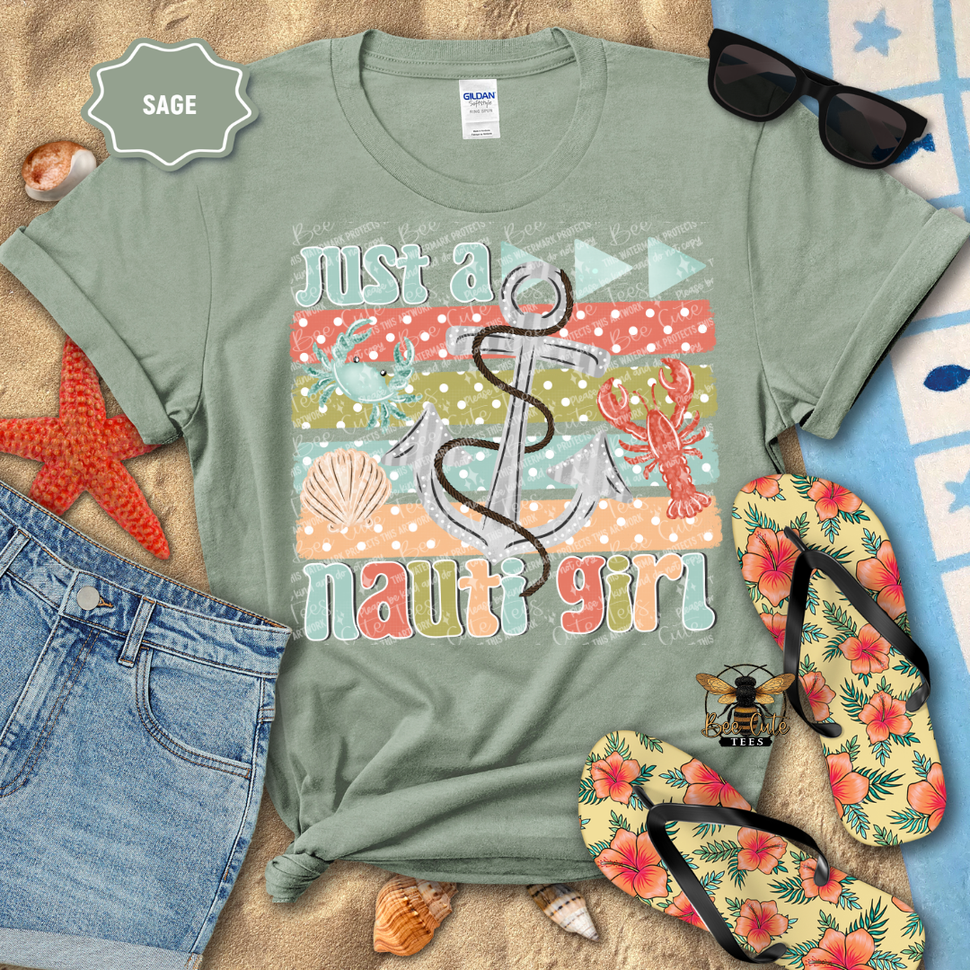 Sage green t-shirt with 'Just a nauti girl' graphic on a beach-themed background with sunglasses, flip-flops, and starfish.