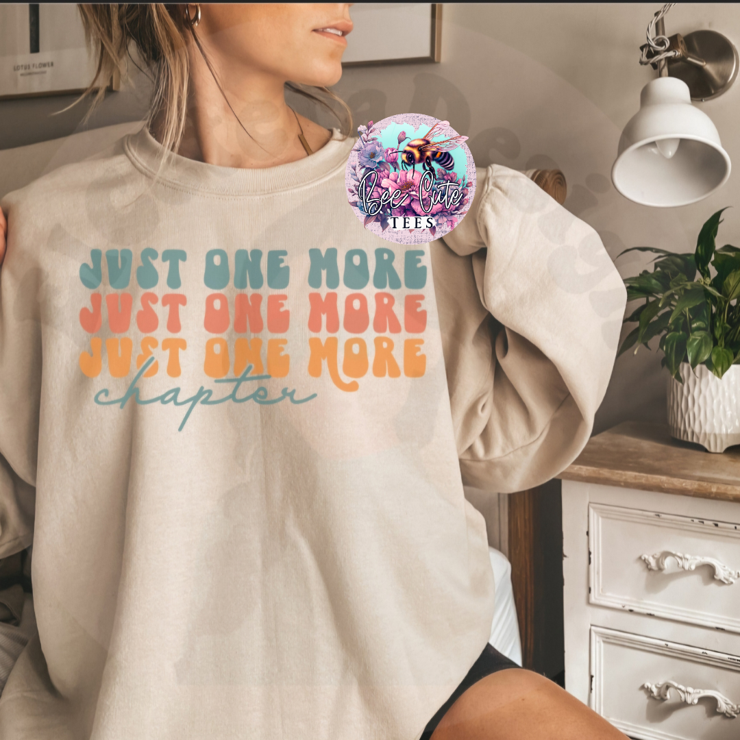 Person wearing a beige sweatshirt with colorful text in a home setting