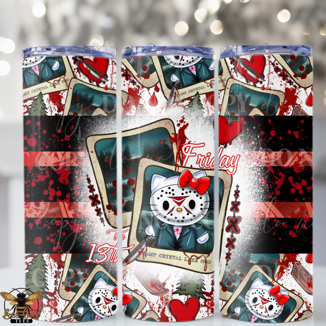 Three tall skinny tumblers with a horror-themed 'Friday the 13th' design, featuring a kitty in a suit and mask, hearts, and playing card graphics, shown against a blurred festive background.