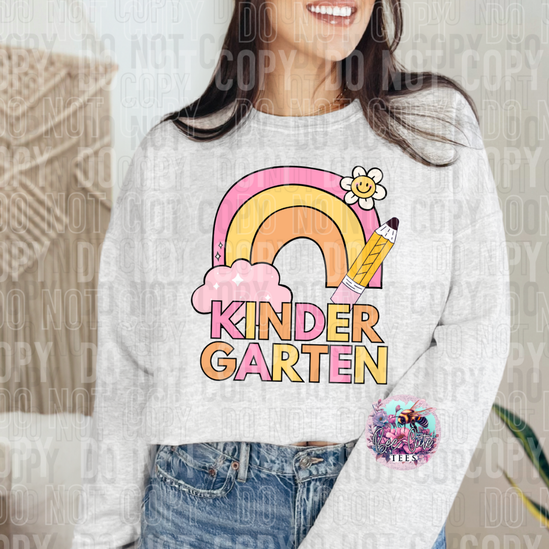Person wearing a sweatshirt with a rainbow and pencil design, labeled 'KinderGarten'.