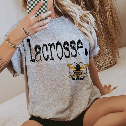Person wearing a gray 'Lacrosse' t-shirt with a logo and text.