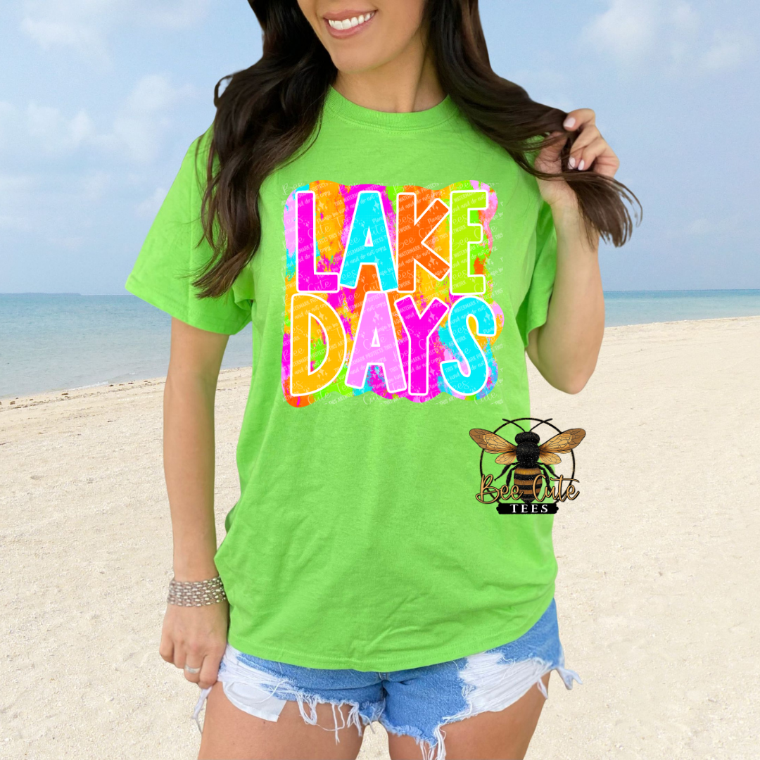 Person wearing a bright green t-shirt with 'LAKE DAYS' text on a beach