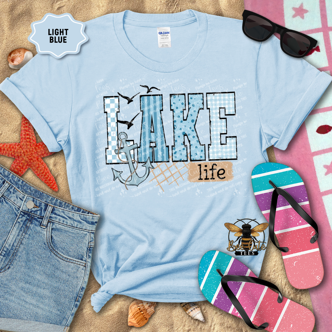 Light blue t-shirt with 'Lake life' design on a beach-themed background