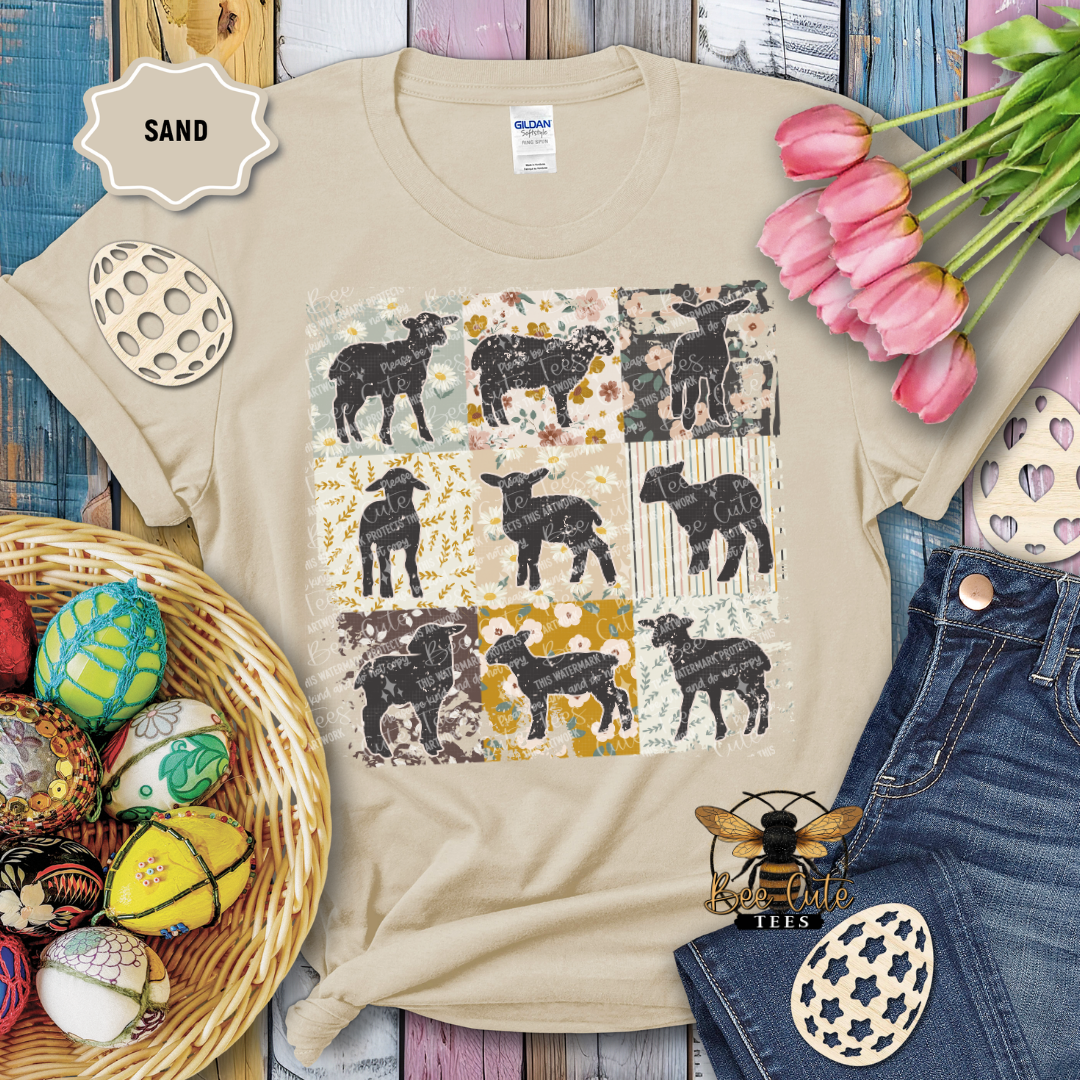 Beige t-shirt with lamb pattern, surrounded by Easter decorations on a wooden surface.