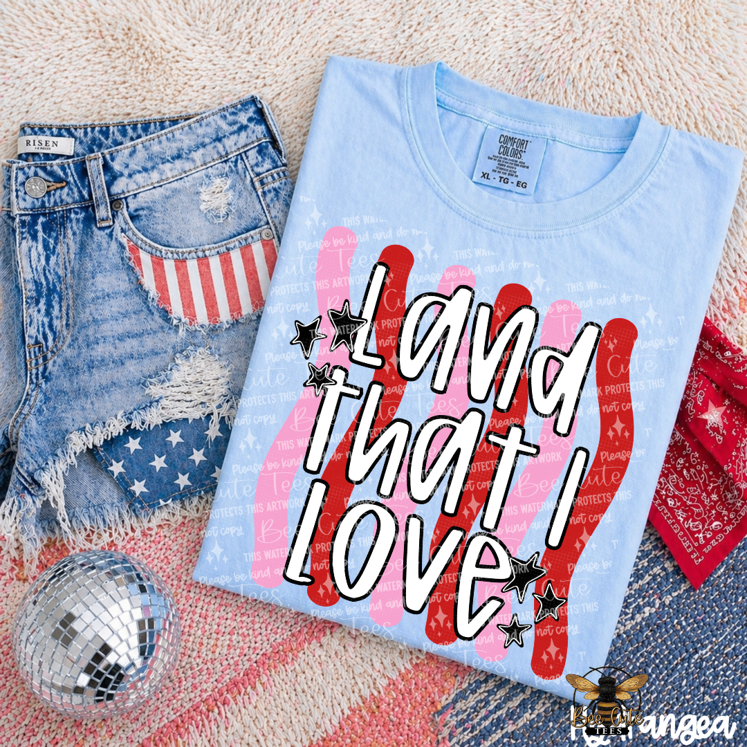 Light blue t-shirt with 'I love that I love' design, distressed jeans, and disco ball on a textured surface.