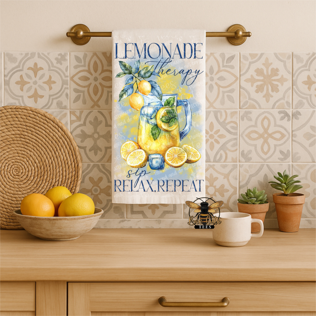 Kitchen towel with lemon design and text hanging on a towel rack, with lemons and a mug on a counter.