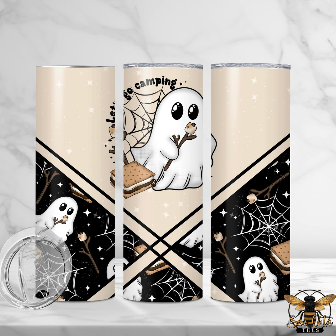 Three views of a skinny tumbler with a Halloween-themed 'go camping' design, featuring cartoon ghosts, spiderwebs, and s'mores on a beige and black background, shown with a clear lid on a marble surface.