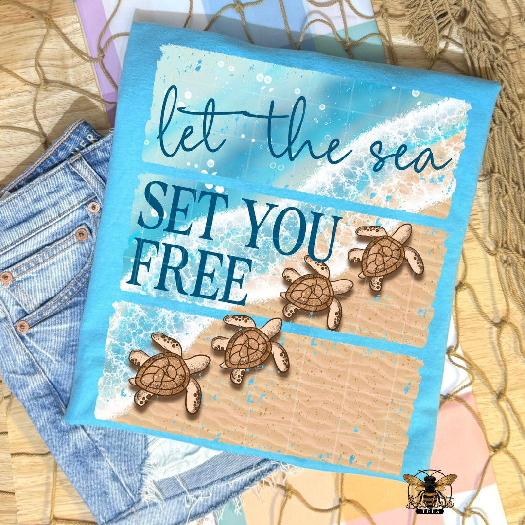 Blue t-shirt with sea turtle design and 'let the sea set you free' text on a textured surface.