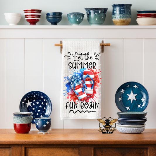 Decorative kitchen set with 'Let the Summer Fun Begin' towel, plates, and bowls on a wooden shelf.