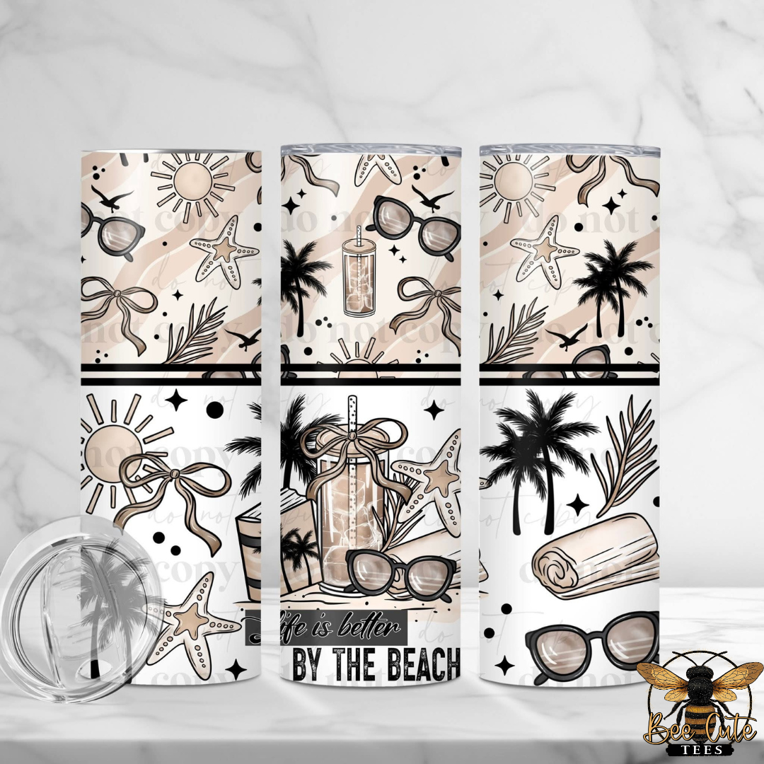 Three tumblers with beach-themed designs on a white background