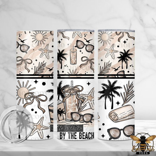 Three tumblers with beach-themed designs on a white background