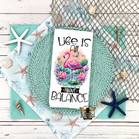 Tea Towel with flamingo design and 'Life is all about balance' text on a textured surface with decorative elements.