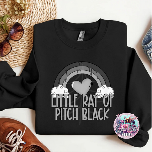 Black sweatshirt with 'Little Ray of Pitch Black' design on a white surface with accessories.