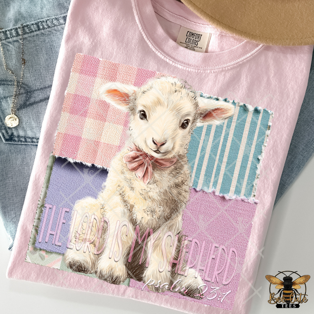 Pink t-shirt with a lamb graphic and 'The Lord is my Shepherd' text, displayed with jeans.