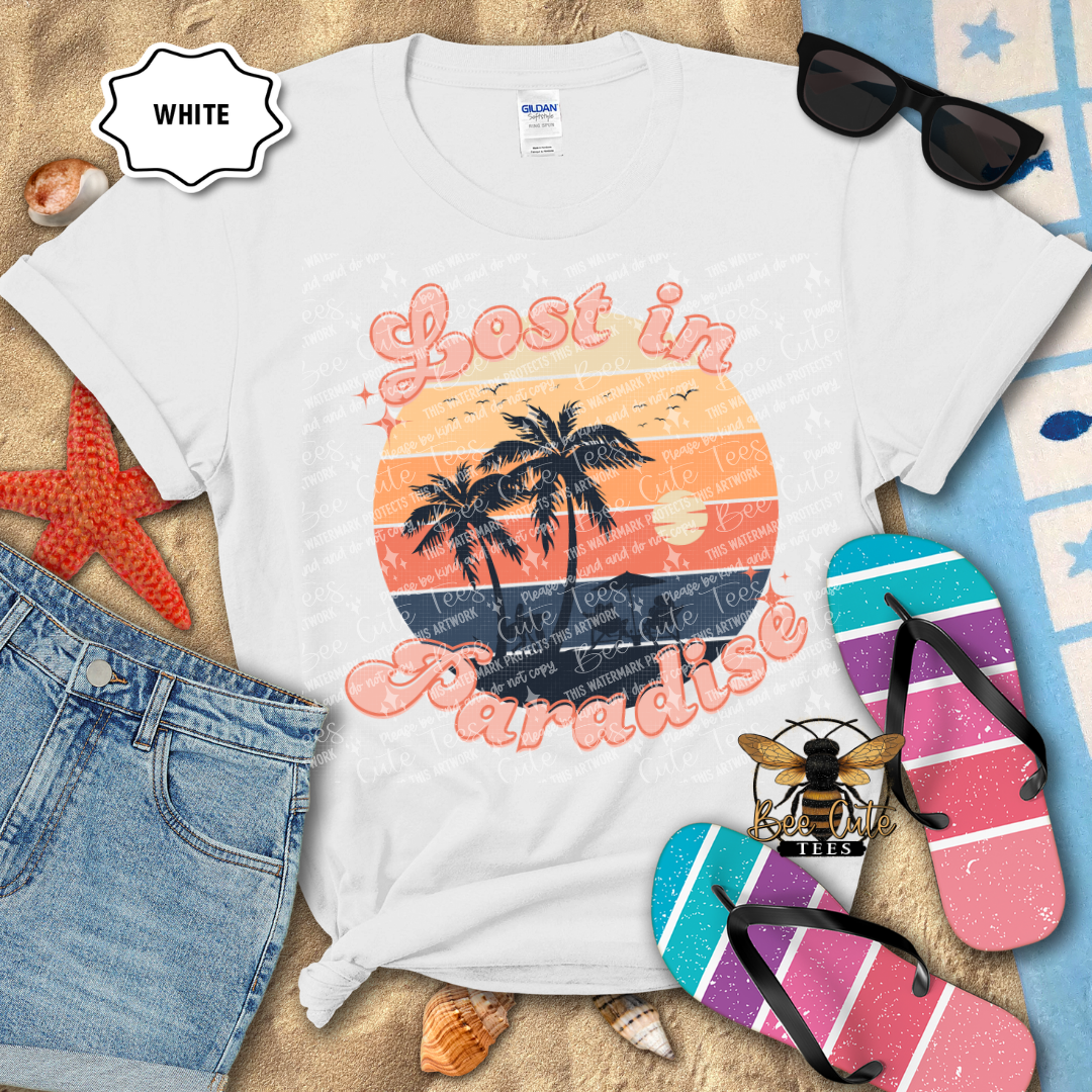 White t-shirt with 'Lost in Paradise' design on a beach-themed background with sunglasses, flip-flops, and denim shorts.