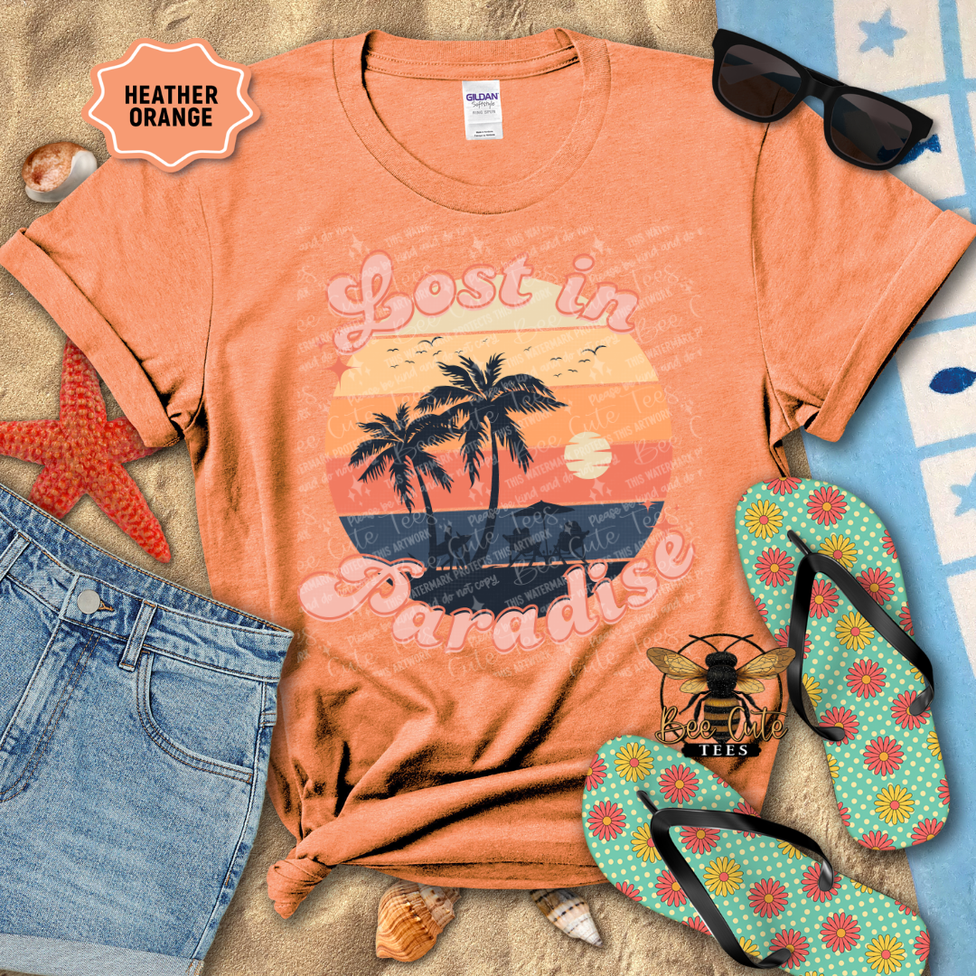 Heather orange t-shirt with 'Lost in Paradise' design, sunglasses, jeans, starfish, and flip-flops on a beach-themed background.