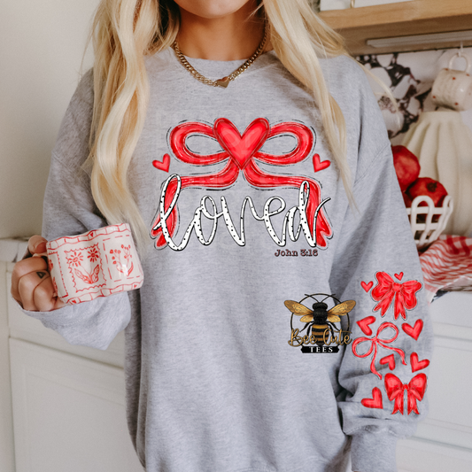 Person wearing a gray sweatshirt with red and white designs, holding a mug.