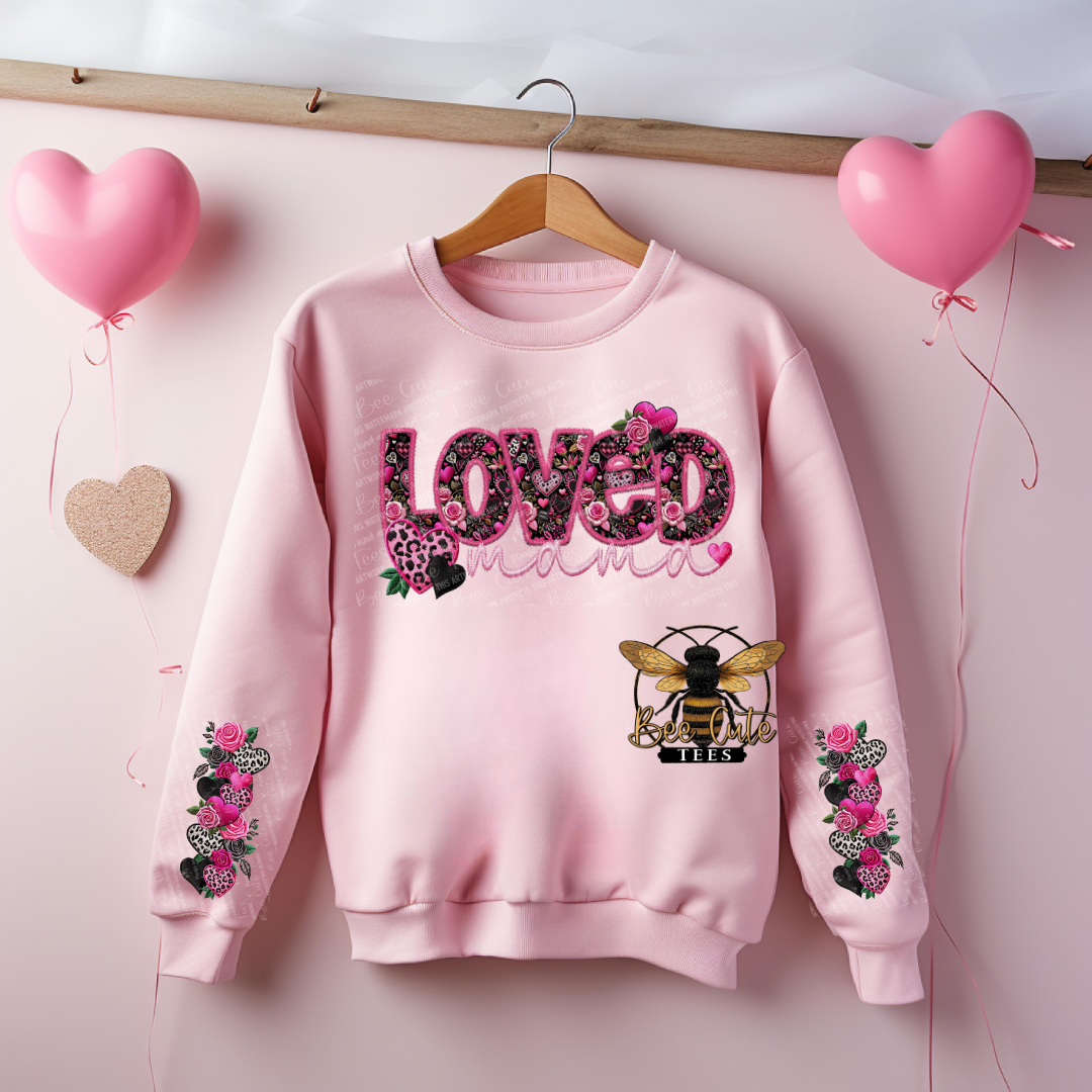 Pink sweatshirt with 'LOVED' text and bee design on a pink background with heart balloons.