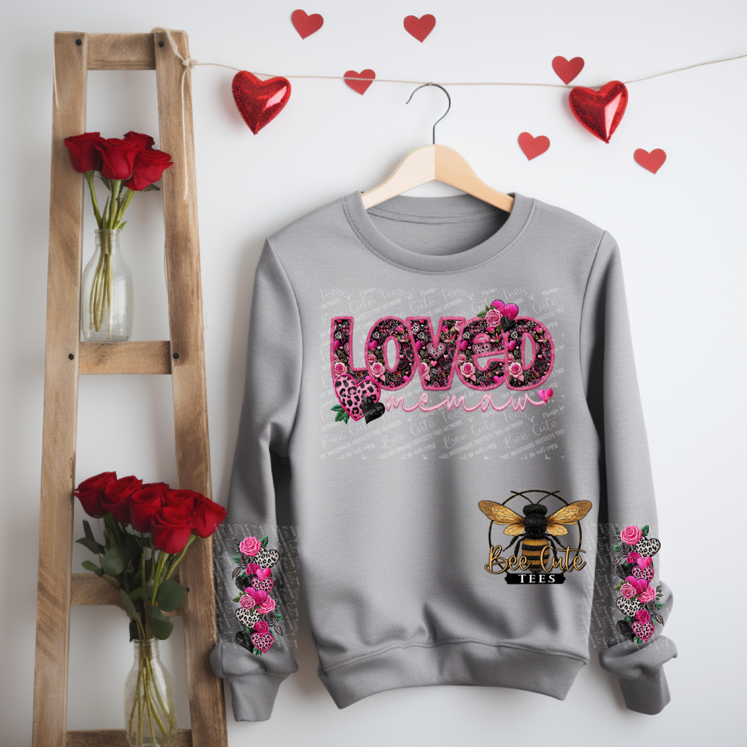 Gray sweatshirt with floral designs and text, hanging on a wooden hanger against a white wall with heart decorations.