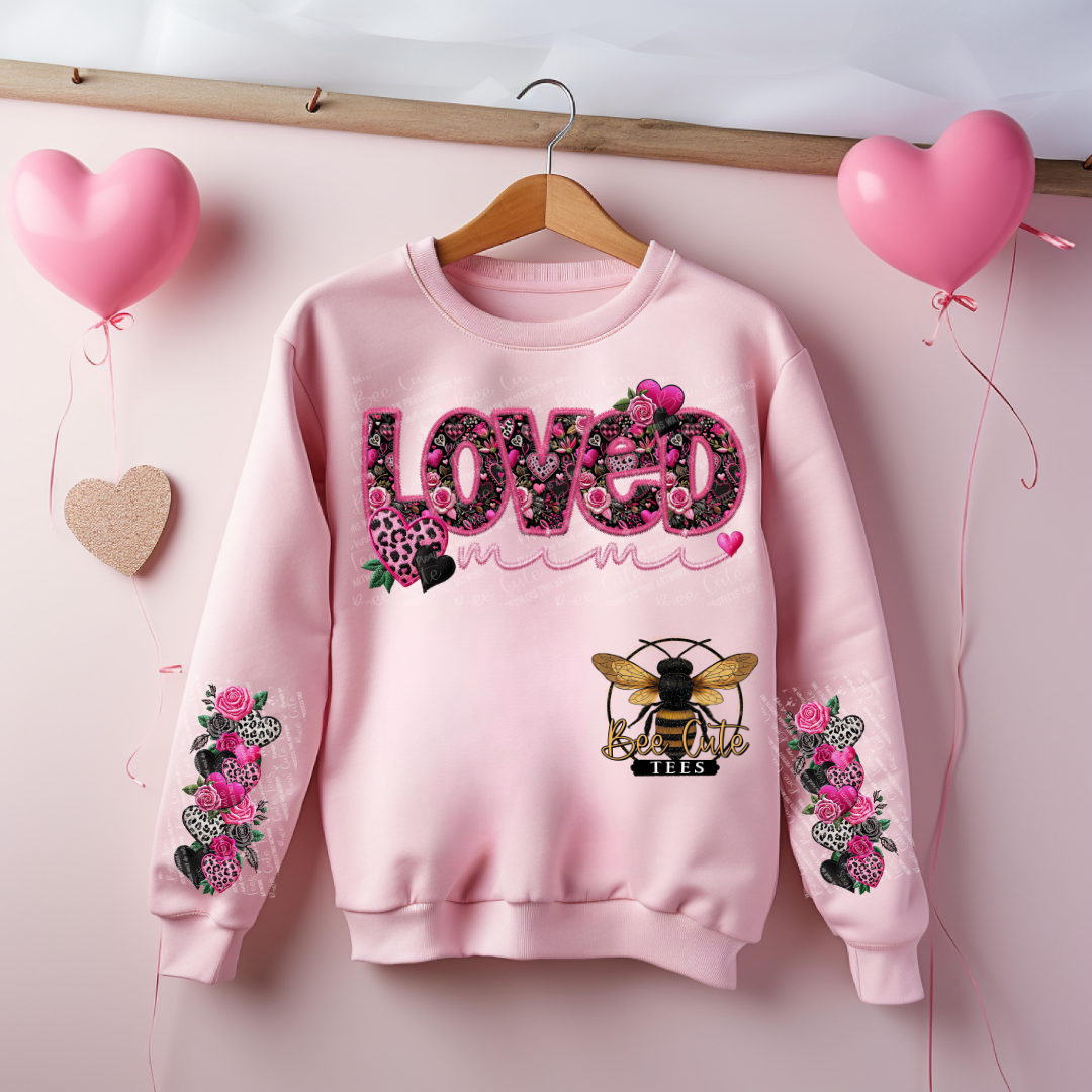 Pink sweatshirt with floral and bee design on a pink background with balloons
