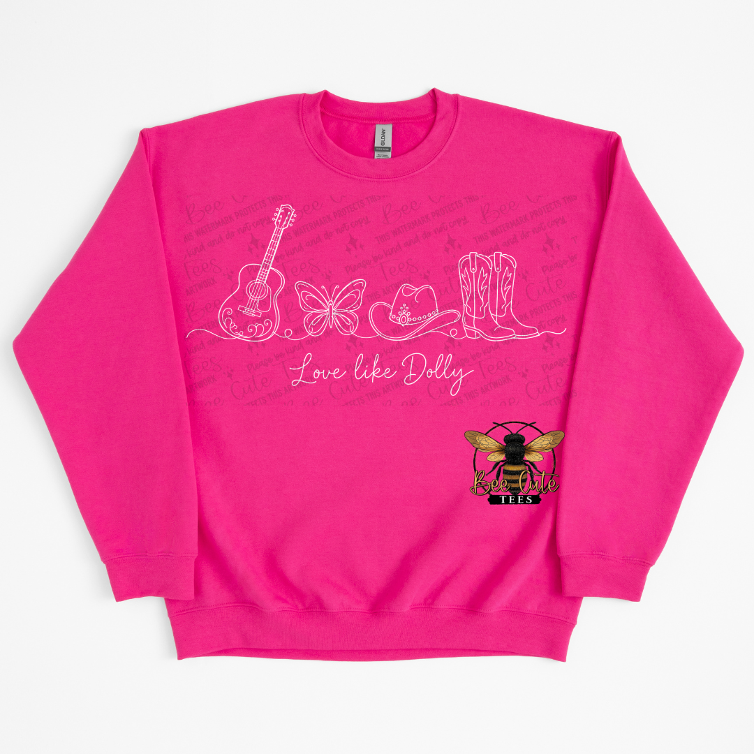 A bright pink crewneck sweatshirt featuring white line art illustrations of a guitar, butterfly, cowboy hat, and boots, with the text 'Love like Dolly' across the front. A small bee logo is printed on the lower right front.