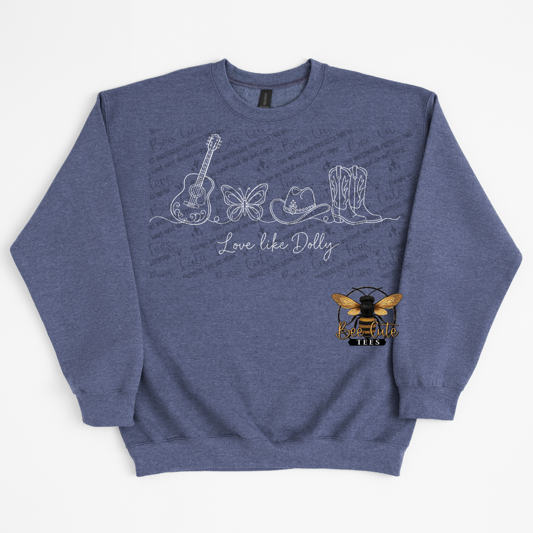 A heathered blue crewneck sweatshirt featuring white line art illustrations of a guitar, butterfly, cat, and cowboy boots, with the text 'Love like Dolly' and a small bee logo on the lower right front.