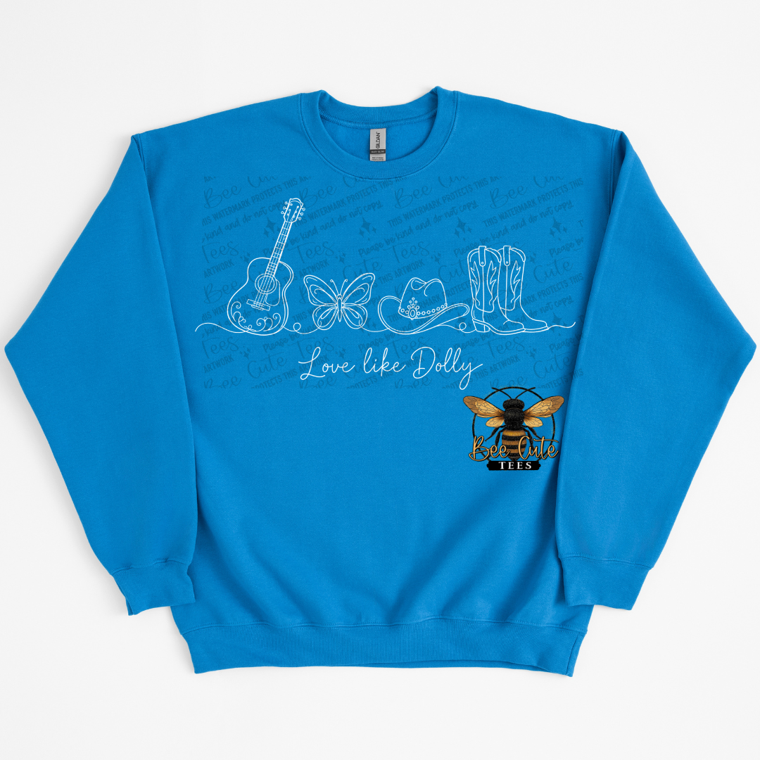 A bright blue crewneck sweatshirt featuring a white line art graphic of musical instruments, a butterfly, a cowboy hat, and boots, with the text 'Love like Dolly' and a bee logo.