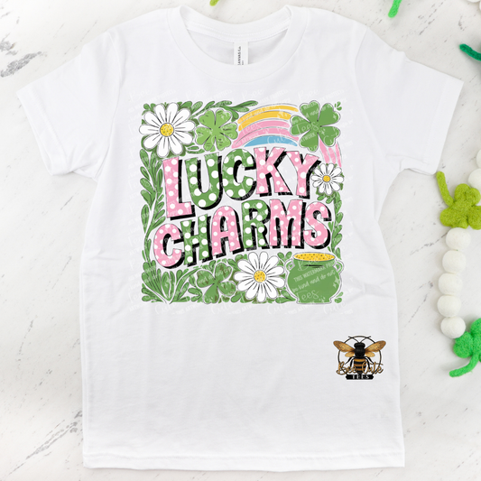White t-shirt with 'Lucky Charms' design featuring flowers and a rainbow on a white background.
